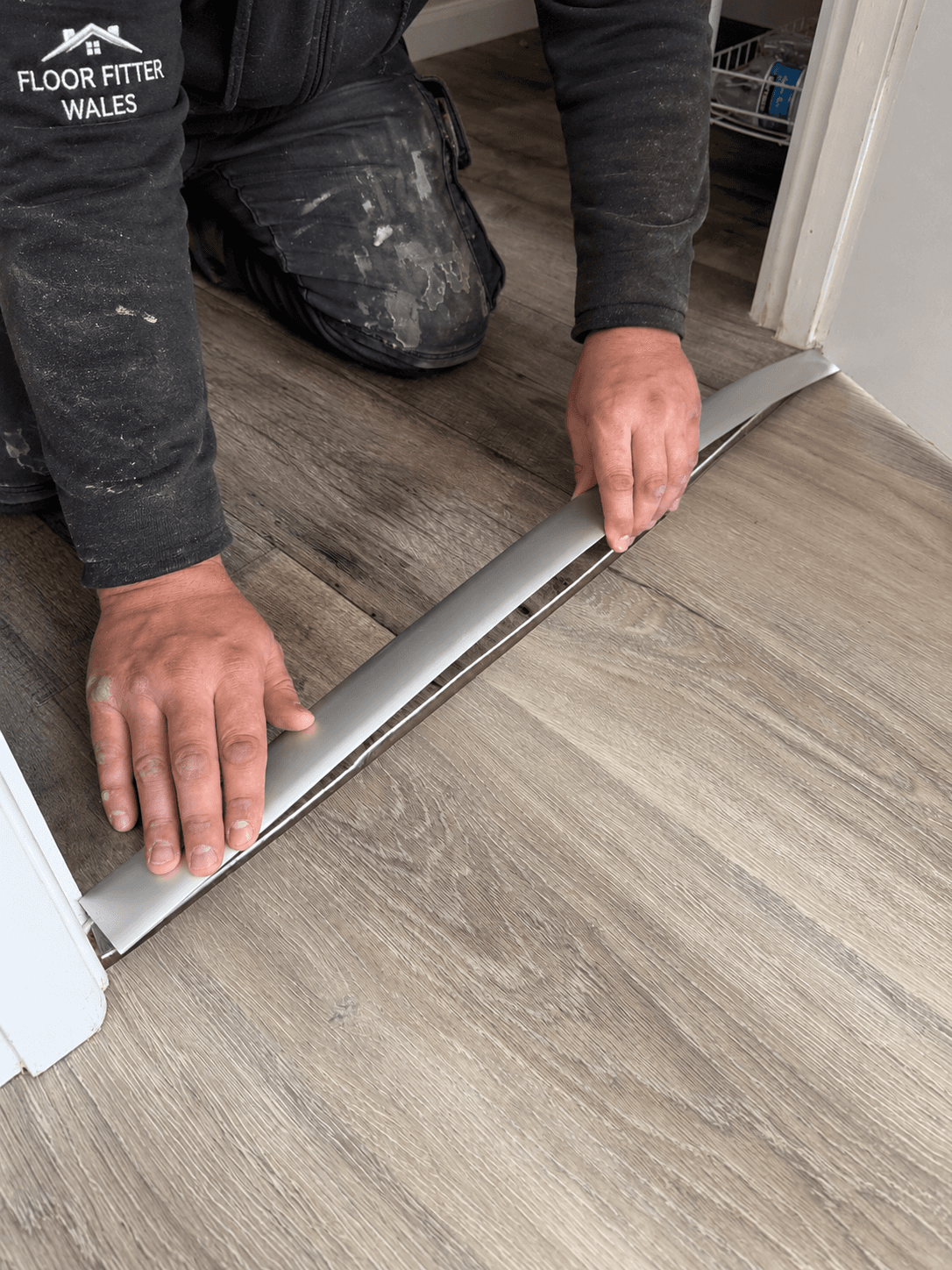 Fitting a metal transition strip across a doorway between wood-effect floors