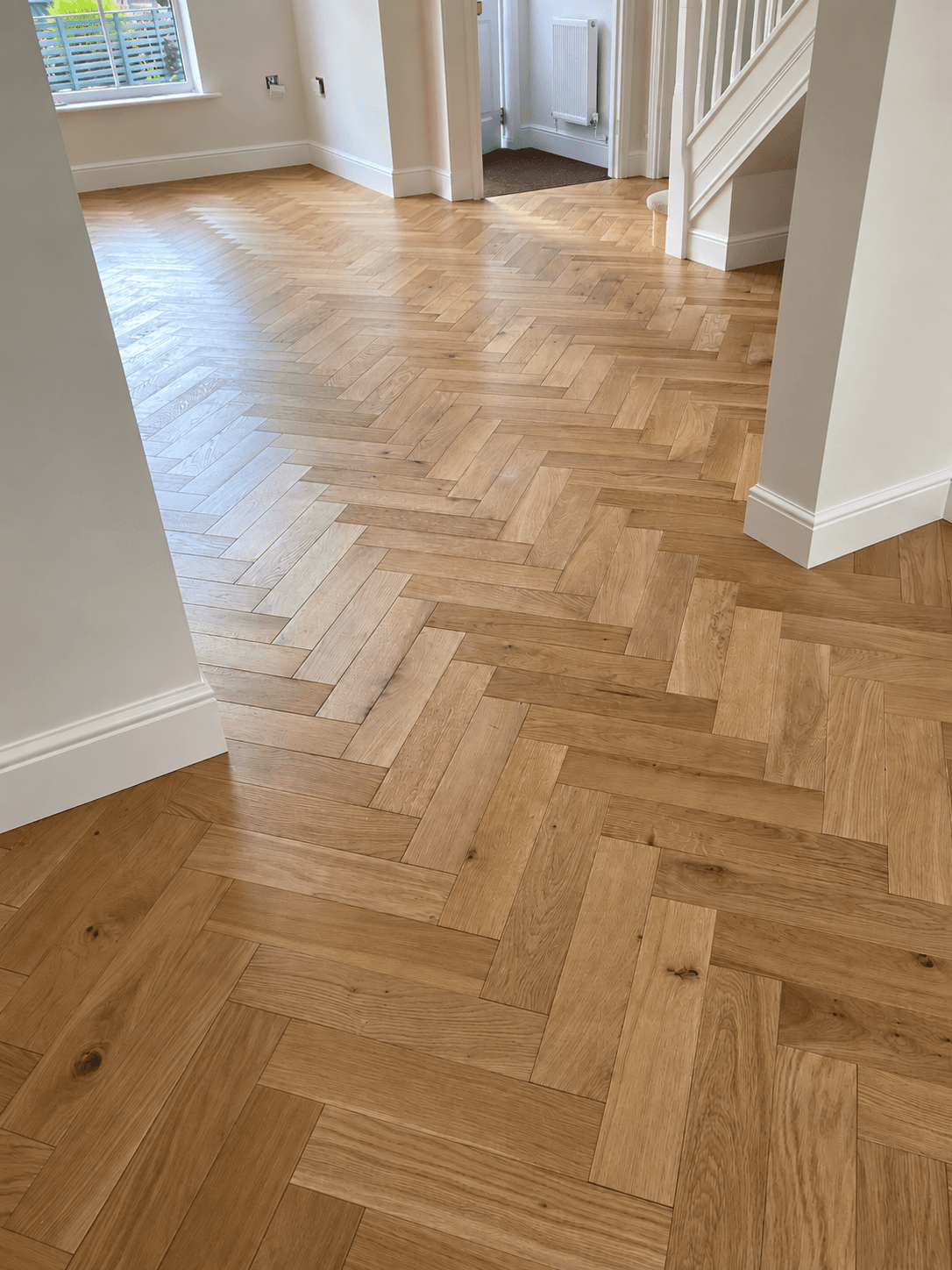 Finished herringbone flooring flowing through adjoining rooms