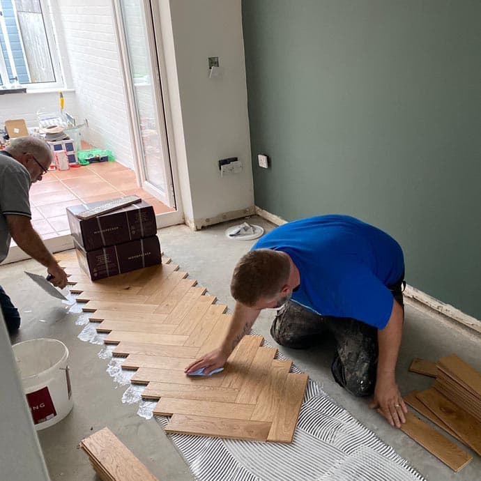 An installer setting out the first rows of a herringbone floor