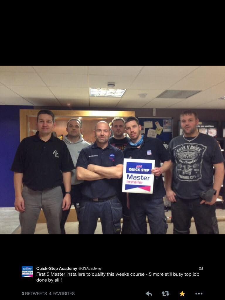 Installer training group holding a Quick-Step Master Installer sign