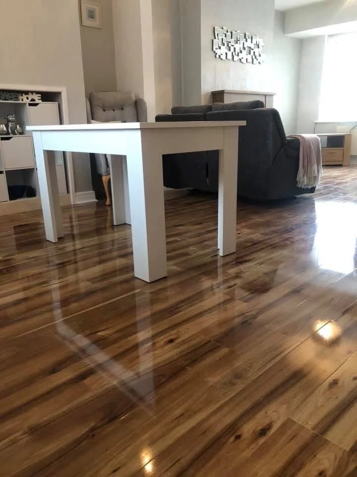 High gloss honey-toned laminate in a living room, reflecting the light around a white dining table