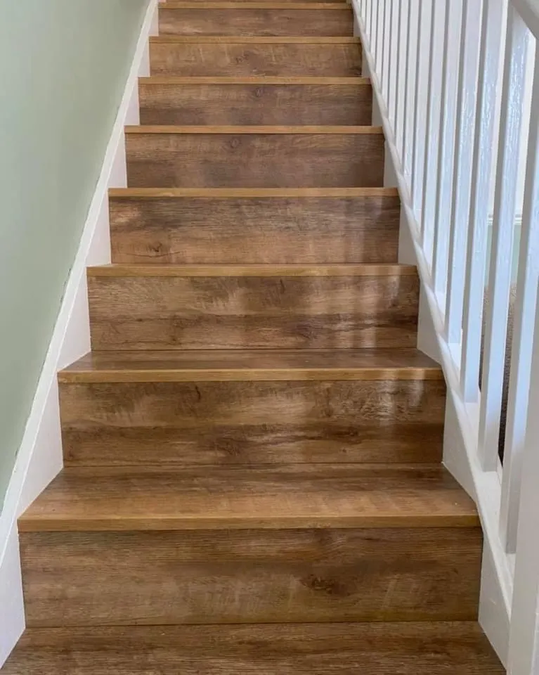 Rustic oak laminate treads and risers on a straight staircase with white spindles