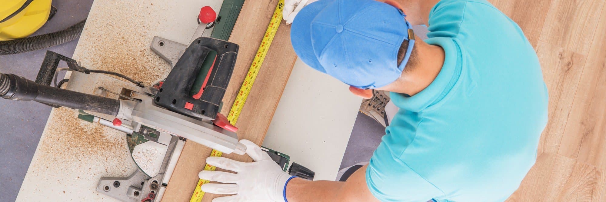 A length of laminate being measured and cut during a floor installation
