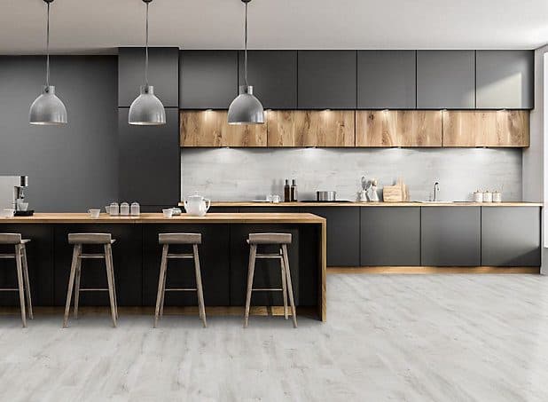 A modern kitchen with pale high gloss laminate flooring reflecting the light