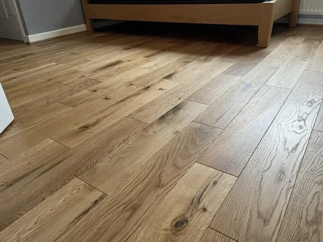 Close view of brushed and matt lacquered engineered oak boards showing the grain and knots