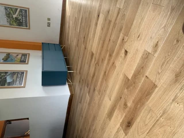 Engineered oak flooring in a dining room with a blue sideboard and framed Welsh travel prints