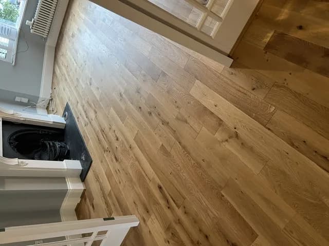 Engineered oak boards running up to a cast iron fireplace with a white surround in a period lounge